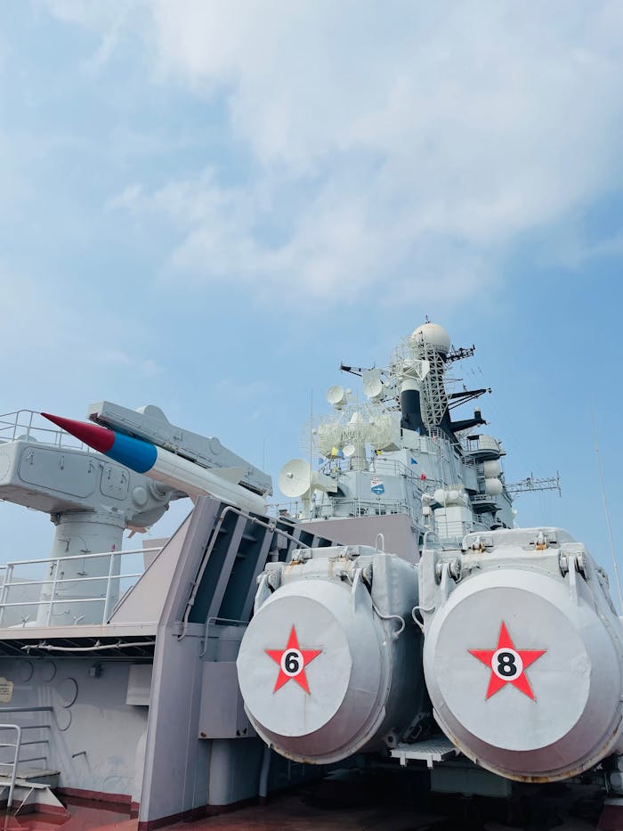 A detailed view of a naval battleship featuring missile launchers under a clear sky in Tianjin, China.