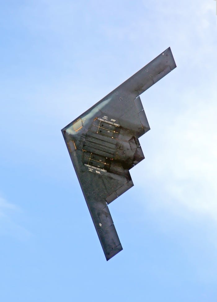 A B-2 Stealth bomber shows its underside as it makes a photo pass at an air show..